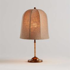 a lamp that is on top of a wooden base with a brown shade over it