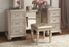 a bedroom with a vanity, mirror and stool next to a flower vase on the floor