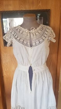 "Beautiful handiwork on this slip that can be worn as a dress as well. In decent shape for her age but does have several flaws holes and stains. Many repairs. One shoulder has a break in the crochet. Stains are visible when looking close on back of skirt and front has small amount on skirt and middle button area of crochet on bodice. There are seam marks that show someone took it up at some point. This is still in wearable condition but would love a little love too. Chest 35\" Waist 24\" Hips op Cotton Vintage Dress With Lace Trim For Daywear, Vintage Cotton Dress With Lace Trim, Vintage Cotton Dresses With Lace Patchwork, Daywear Vintage Lace Dress With Lace Collar, Vintage Sleeveless Broderie Anglaise Dress, Sleeveless Lace Vintage Dress With Lace Trim, Vintage Lace Dress With Lace Collar For Daywear, Cottagecore Lace Vintage Dress For Daywear, Vintage Sleeveless Dress With Lace Collar