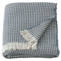 a gray and white checkered blanket with fringes