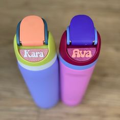 two colorful cups sitting on top of a wooden table next to each other with the word kara written on them