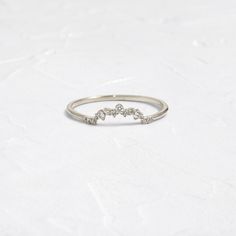 a white gold ring with five diamonds on it, sitting on top of a table