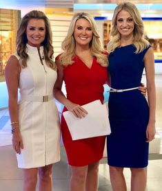 three women standing next to each other in front of a tv screen wearing red, white and blue dresses