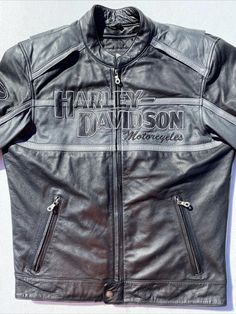 Harley-Davidson Men's Motorcycle Jacket - Black Leather Elevate your riding experience with the Harley-Davidson Men's Motorcycle Jacket. Crafted from premium quality leather, this jacket combines style, comfort, and durability to ensure you look and feel your best on and off the road. Whether you're hitting the open road, attending a casual event, or dressing up for a formal occasion, this jacket is designed to suit every moment. Product Description: *Material: Crafted from genuine leather, this Black Cafe Racer Leather Jacket For Biker Events, Black Biker Outerwear For Outdoor, Black Biker Style Outerwear For Outdoor, Black Leather Cafe Racer Jacket For Motorcycling, Black Biker Outerwear For Outdoor Activities, Outdoor Moto Biker Jacket With Zipper Closure, Moto Style Biker Jacket With Zipper For Outdoor, Black Moto Leather Jacket For Motorcycling, Black Cafe Racer Jacket For Motorcycling