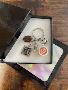 a keychain with some charms in it on top of a wooden table next to a cd