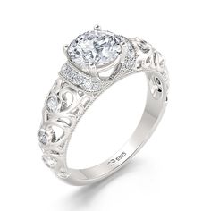 The beautiful engagement ring showcases a stunning round-cut stone center stone. Sparkling stones and intricate details create the ring's shank. On your wedding day, the coordinating stone and milgrain wedding band lends to the heirloom quality and completes this elegant ensemble.Carat Weight: 1.9 ctStone Size: 6.5 mmStone Type: Jeulia® StoneNumber of Stones: 1 Stone Color: Diamond WhiteStone Shape: RoundCarat Weight: 0.385 ctStone Size: 1,1.6,1.8,2 mmStone Type: Jeulia® StoneNumber of Stones: 2 Classic Bridal Sets With Diamond Center Stone, Classic Round Bridal Sets For Formal Occasion, White Gold Bridal Set With Round Band, Classic Diamond White Bridal Sets With Diamond Accents, White Gold Bridal Set With Round Cut Center Stone, Classic Bridal Sets In Diamond White With Diamond Accents, Exquisite Anniversary Diamond Ring With Accent Stones, Elegant Diamond Bridal Sets For Promise, Elegant Bridal Sets With Diamond Accents For Marriage