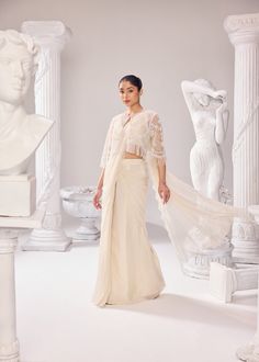 Our rich craftsmanship adorn the jacket. The organza saree has scallops on all the corners of the drape, paired with an organza plunge neckline sleeveless blouse. Get ready to make a statement with this effortless silhouette, delicate embroidery and the soothing hue. Colour: Off- White Material: Net- Jacket, Organza- Saree, Organza- Blouse No of components: 3 Surface Ornamentation: Hand Embroidery Care Instructions: Dry Clean Shipping Time: 3-4 weeks Jacket Saree, Surface Ornamentation, Shirt Jacket Men, Organza Blouse, Drape Saree, Delicate Embroidery, Organza Saree, Plunge Neckline, Silk Roses