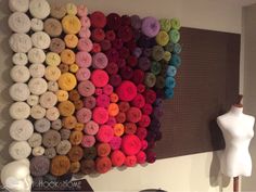 there is a wall decoration made out of different colors of yarns and buttons on the wall