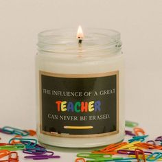 a candle with the words teacher on it surrounded by colored paper clips