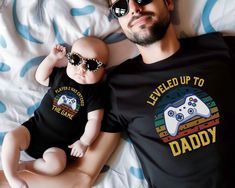 This leveled up to Daddy Tshirt would make the perfect announcement for your new baby! This New Gamer Dad shirt is made with a soft cotton and a quality print that will have you fall in love with it over and over again. This Premium crafted t-shirt features a crew neck, short sleeve and designed for a super soft and comfortable feel with a high quality cotton Blend. Our t-shirts are made from 4.2 ounce cotton. All solid colors are 100% Airlume combed and ring-spun cotton and all heathered colors Playful T-shirt For Father's Day, Playful Father's Day Family T-shirt, Playful Crew Neck T-shirt For Father's Day, Father's Day Playtime T-shirt With Short Sleeves, Father's Day Short Sleeve Playtime T-shirt, Father's Day Playtime T-shirt Short Sleeve, Playful Letter Print Tops For Father's Day, New Father, New Fathers