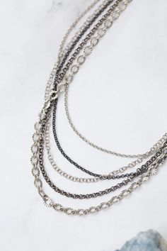 Experience the beauty and versatility of the Reflections Collection. Each piece is thoughtfully handcrafted using carefully chosen materials. This multistrand necklace measures 16.5-18.5" and is completed an antique silver plated brass extender chain and lobster claw clasp. Elevate your style with Reflections. Antique Silver Plated Brass (lead and nickel free) Mixed Metal 16.5-18.5", adjustable with antique silver plated brass lobster claw clasp We hand select our natural materials, thus there m Elegant Pewter Necklace In Antique Silver, Elegant Antique Silver Pewter Necklace, Multi-strand Silver Chain Jewelry, Silver Necklaces With Lobster Clasp For Layering, Silver Multi-strand Jewelry With Unique Variations, Elegant Silver Layered Necklace With Lobster Clasp, Silver Multi-strand Oxidized Jewelry, Nickel-free Multi-strand Silver Necklace, Multi-strand Metal Jewelry With Lobster Clasp