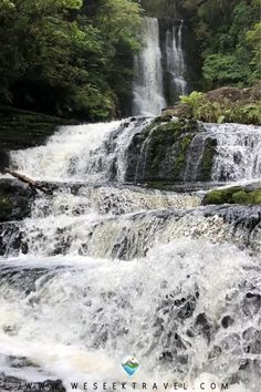 a waterfall in the middle of a forest with lots of water flowing down it's sides