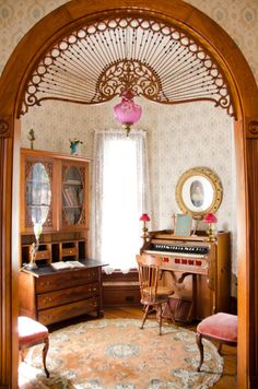 a room with a desk, chair and mirror in it