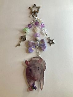 a keychain with an animal and charms attached to it's side on a white surface