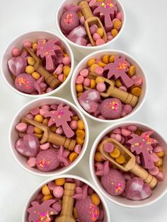 four white bowls filled with pink and yellow candies