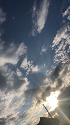 the sun shines brightly through some clouds in the sky over a house and power lines