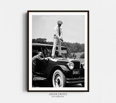 an old black and white photo of a man on top of a car