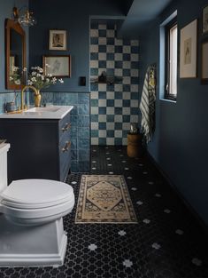 a white toilet sitting next to a bath tub in a bathroom on top of a black and white checkered floor