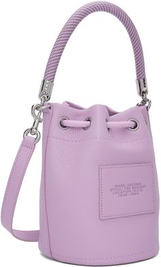 Grained leather shoulder bag in purple. · Braided rope carry handle · Adjustable and detachable crossbody strap · Logo and text embossed at face · Logo patch at back face · Cord-lock drawstring closure · Card slot at interior · Partial twill lining · H8.5 x W8 x D7 Supplier color: Wisteria Purple Travel Bag With Silver-tone Hardware, Purple Bucket Shoulder Bag With Detachable Strap, Purple Bucket Bag With Adjustable Strap, Purple Crossbody Bucket Bag With Adjustable Strap, Purple Bucket Bag With Adjustable Strap For Travel, Purple Leather Bucket Bag, Marc Jacobs Bucket Bag, Purple Braids, Greeting Card Inspiration