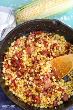 corn and bacon in a skillet with a wooden spoon