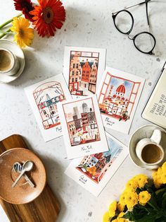 four postcards with pictures of buildings on them next to some flowers and a cup of coffee