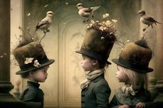 three children wearing top hats with birds on them and one child looking at the other