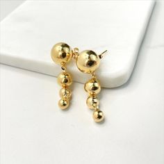 "18k Gold Filled Drop Balls Earrings - Earring Size: Drop Height: 41mm | Big Ball Diameter: 12mm | Large Ball Diameter: 8mm | Medium Ball Diameter: 6mm | Small Ball Diameter: 5mm 💎 With new products daily, quality and competitive prices, in DiJu Jewelry you find the most unique styles of modern designs, always looking for elegance and market trends. *Helping your Jewelry Businesses Grow *Starting your Own Business *Making your Own Collection: DiJu Jewelry ever brings Better Moments for your Lif Gold Hypoallergenic Round Bead Earrings, Gold Hypoallergenic Earrings With Round Beads, Gold Earrings With Round Beads For Pierced Ears, Gold Hypoallergenic Earrings, Hypoallergenic Yellow Gold Round Bead Earrings, Gold Earrings With 14k Round Beads, 14k Gold Earrings With Round Beads, Gold Round Earrings With Shiny Finish, Classic Gold Earrings With Round Beads