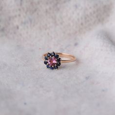 A stunning ring with pink tourmaline and blue sapphires made out of 14k solid gold . The weight of the ring is approx. 2.63g. High polished. This romantic piece of jewelry is a great extraordinary gift and would make a perfect choice for the engagement. You can choose between 14k rose, yellow or white gold. If you want to customise this product or set it with another stones - please write to us. ❤ Hand Made with love in our studio in Prague ❤ Stone details Tourmaline Shape: Round Dimensions: 5 m Pink Multi-stone Sapphire Ring, Pink Multi-stone Sapphire Ring, Fine Jewelry, Pink Multi-stone Sapphire Ring In Fine Jewelry Style, Pink Tourmaline Sapphire Ring, Pink Multi-stone Round Sapphire Ring, Pink Sapphire Ring Birthstone Fine Jewelry, Pink Tourmaline Sapphire Ring Gift, Pink Sapphire Gemstone Rings, Pink Tourmaline Sapphire Ring As Birthstone