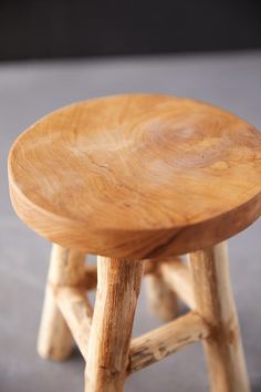 a small wooden stool sitting on top of a cement floor