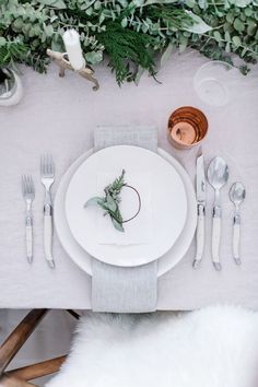 an instagram page with white plates and silverware, greenery on the table