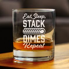 a shot glass with the words eat sleep stack dimes repeat on it sitting on a table