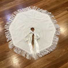 a white table cloth with fringes on the edge and a bow at the top