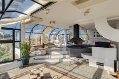 a living room filled with furniture and lots of windows