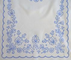 a white and blue table cloth with an embroidered border