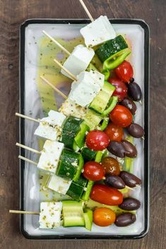 an assortment of vegetables and cheese on skewers