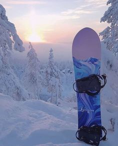 a snowboard sitting on top of a snow covered slope in the middle of winter