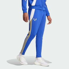 a man in blue tracksuits and white sneakers