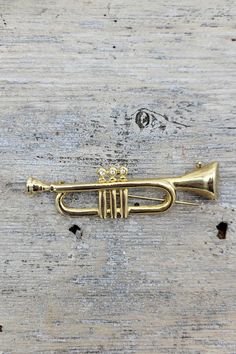 Vintage Brass plated horn pin/ trumpet brooch. Brass plated possibly pewter as their is a bit of weight to this brooch and their are to patina marks on the back from age and wear. Brooch features three (3) jem stones likely qubic zirconia in the center of the pin, and  a locking C clasp closer for safe wear. Lovely piece of jewelry for the holiday season affixed to any coat or sweater.  Approximate Measurements: 3 " L x 1 5" W  Please view all photos before purchasing as all items are previously Jem Stones, Coat Pin, Oct 11, Vintage Brass, Brooch Pin, Patina, Holiday Season, Gold Tones, Plating