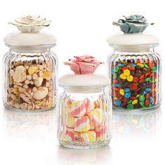 three glass jars filled with candy and candies