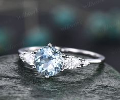 a ring with three pear shaped diamonds on it, sitting on top of a rock