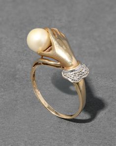 "Find ALEXIS BITTAR Vintage 1940s 14k Hand Ring Motif Ring With Cultured Pearl & Diamond on Editorialist. Details From the decadent early 1940s, this stunning Victorian inspired 14k gold ring has the detailed silhouette of a hand holding a cultured pearl with a silver tone ruffled sleeve accented with diamonds. For further details, additional photos or a private consultation on this style, please contact service@alexisbittar. com. 14k gold, pearl, diamond UPC: 990100071041 Measurements .375\" north/south Care To clean, gently wipe the surface with a soft cloth. For additional care instructions visit our FAQ page. | Vintage 1940S 14K Gold Hand Ring Motif Ring With Cultured Pearl & Diamond in Gold/Silver Size 6 by Alexis Bittar" Gold Hand Ring, Dainty Wedding Ring, Pearl Engagement Ring, Pearl And Diamond Ring, Hand Ring, Stacked Bangles, Gay Wedding, Gold Hand, North South