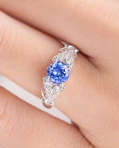 a woman's hand with a blue ring on it