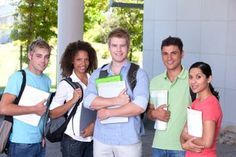 a group of young people standing next to each other in front of a white building