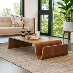 a living room filled with furniture next to a large window and lots of greenery