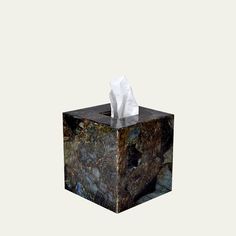 a tissue paper dispenser sitting on top of a marble block