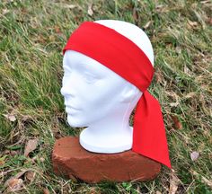 a white mannequin head with a red bandana on it's head