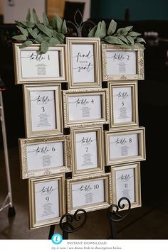 the table numbers are arranged in gold frames with greenery on top and below them