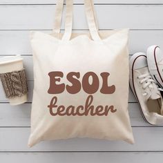 a tote bag with the words esol teacher on it next to some shoes