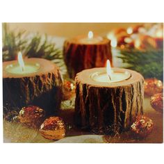 three lit candles sitting on top of wooden logs