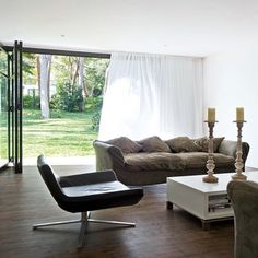 a living room filled with furniture next to a sliding glass door that leads out onto a lush green yard